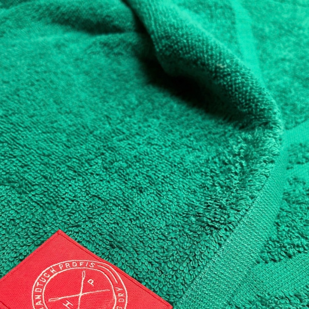 Handtuch Bordüreneinwebung in Grün mit angenähtem Handtuch-Profis-Webetikett, Frottier und Bordüre im Detail