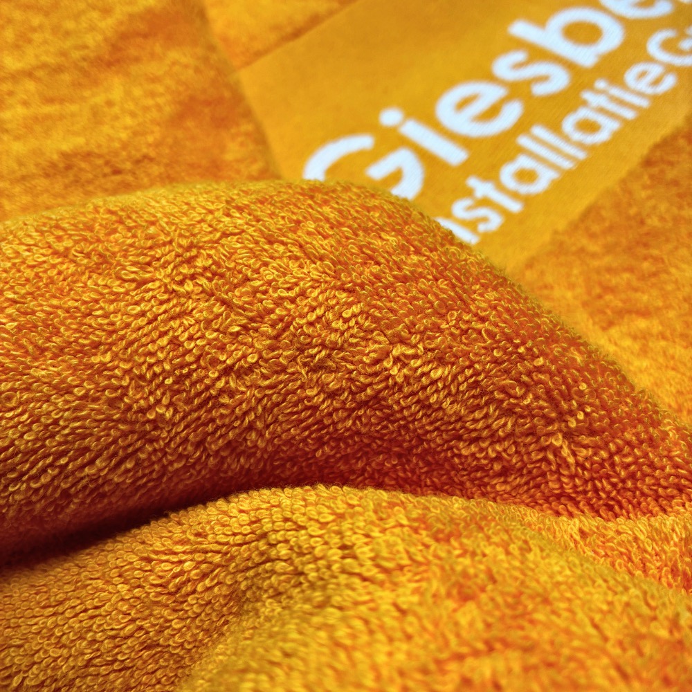 Handtuch Bordüreneinwebung in Orange: weißer Schriftzug in der Bordüre