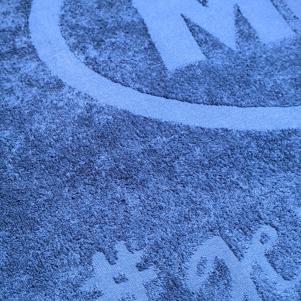 Handtuch Hoch-Tiefwebung in Blau: rundes Logo als Reliefwebung Ton in Ton eingewebt